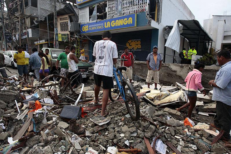 People walk among the debris of a collapsed building on April 17, 2016 after an earthquake hit the northern coastal region of Ecuador. President Correa calls a national emergency after more than 230 were killed and over 1,000 injured in the 7.8-magnitude quake. (Jose Jacome/EFE/Zuma Press/TNS)