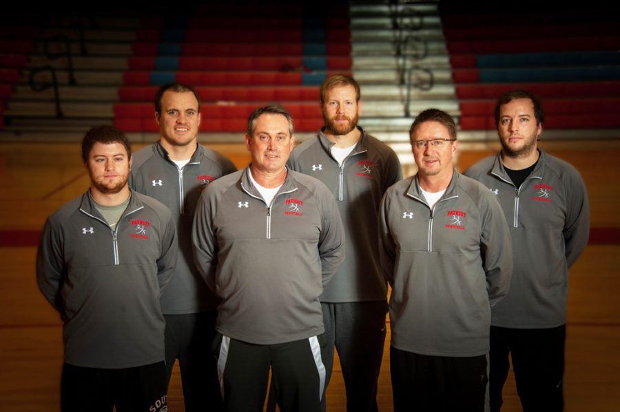 The LHS boys basketball team coaches pose for a picture, Halseth and Embry are front center and right.