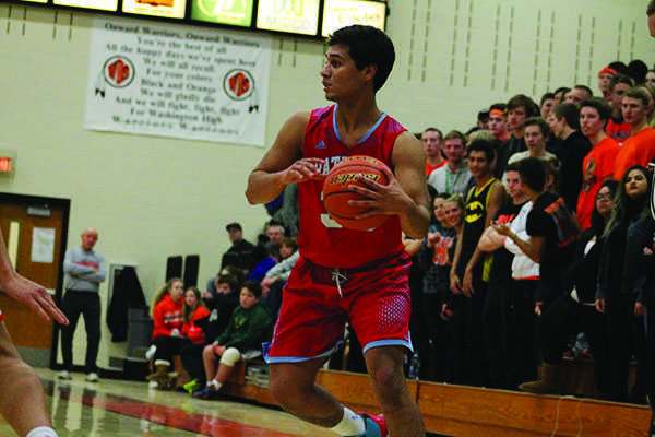 Simon Higgason holds the ball in the action of the game against WHS on Jan. 12.