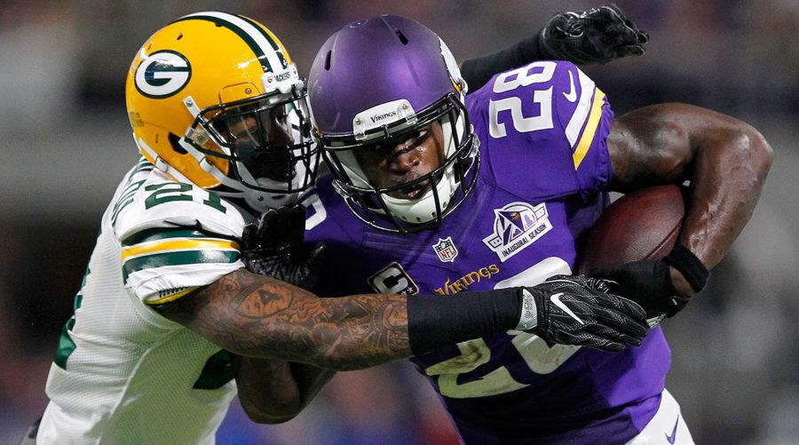 Adrian+Peterson+rips+through+a+Packers+defender.
