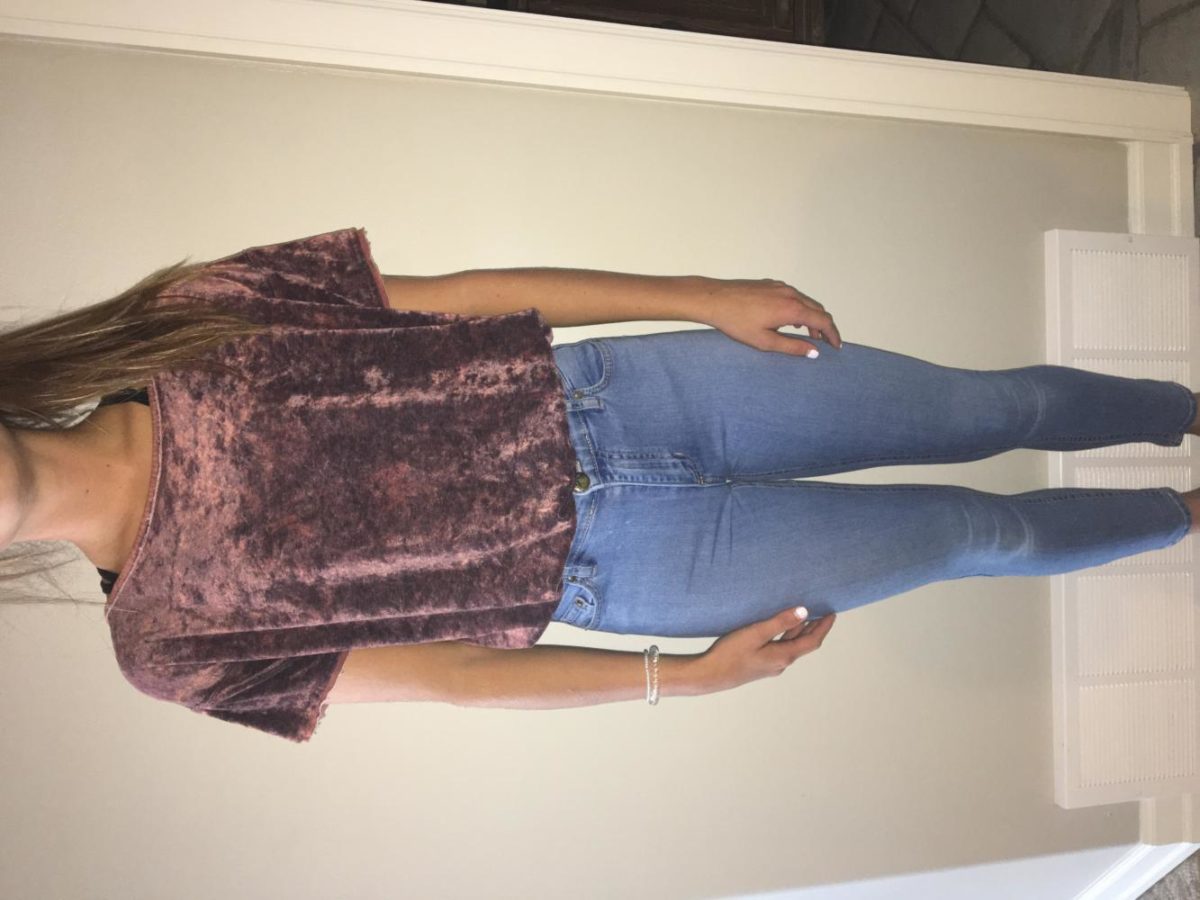 Junior, Anika Jensen wearing a velvet top with light wash high-waisted jeans.