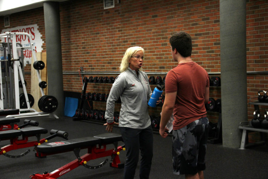 Kaaren Huber giving advice to Rogan Brison, a Weight Lifting student