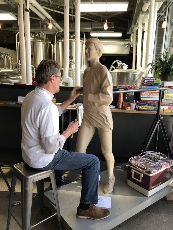 Sculptor Darwin Wolf works on a clay model of Rich Greeno.