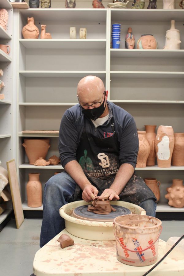 Travis Hinton works on a throwing wheel in his classroom. 