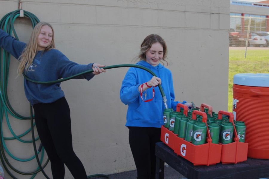 LHS football managers Allison Kolling and Madyson Lawson fill water bottles at practice.