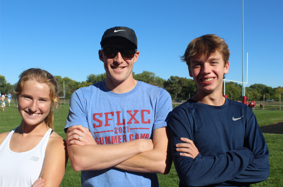 Senior captains of the LHS cross country team Hannah Dumansky and Kadin Groen smiling with their Coach, Luke Jelen.