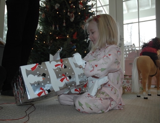 Four-year-old Rachel gleefully tears open a present on Christmas morning.