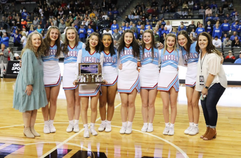 LHS cheer team with the Spirit of six award shortly after winning it at the Girls State tournament.