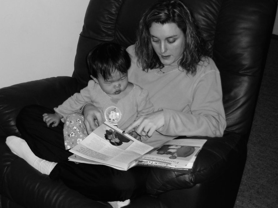 Two-year-old Sandvall and her mom reading the Sunday paper together. 