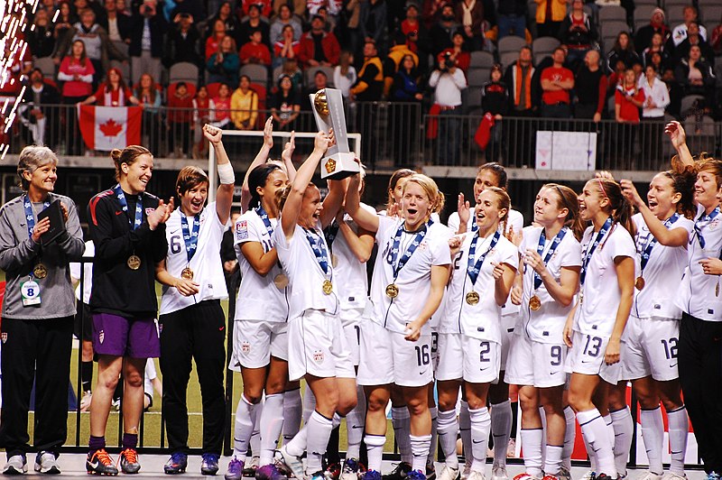The following is the authors description of the photograph quoted directly from the photographs Flickr page.

 The USWNT Celebrates their First Place win as Captain Christie Ramponeraises the trophy at the 2012 CONCACAF Olympic Qualifiers. 