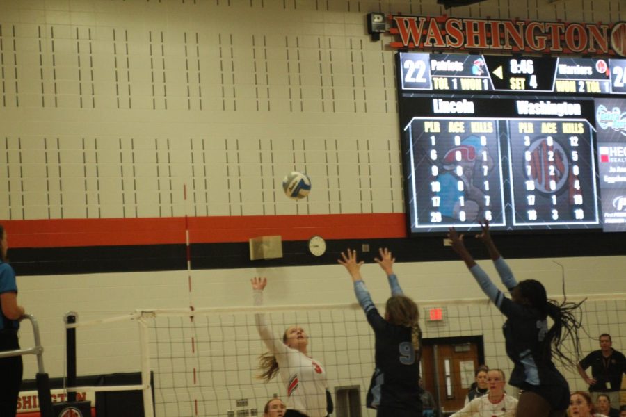LHS players reach high to block balls sent by opposing WHS.