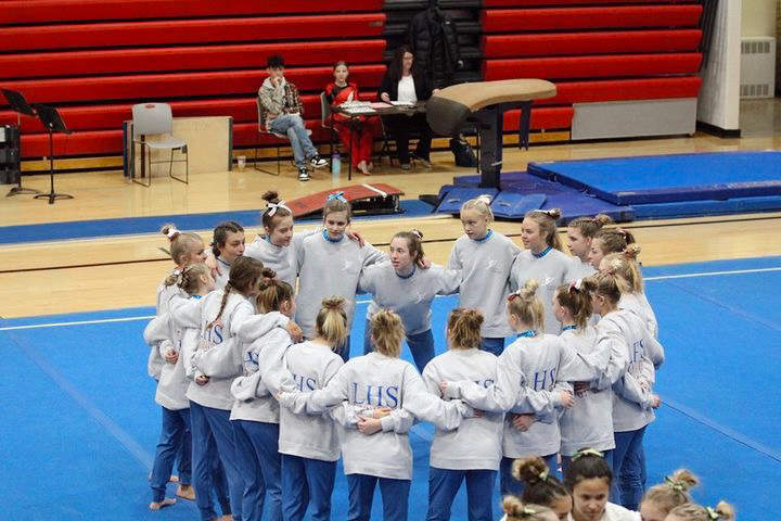 LHS gymnastics team gathering together to have an inspirational talk before their meet.