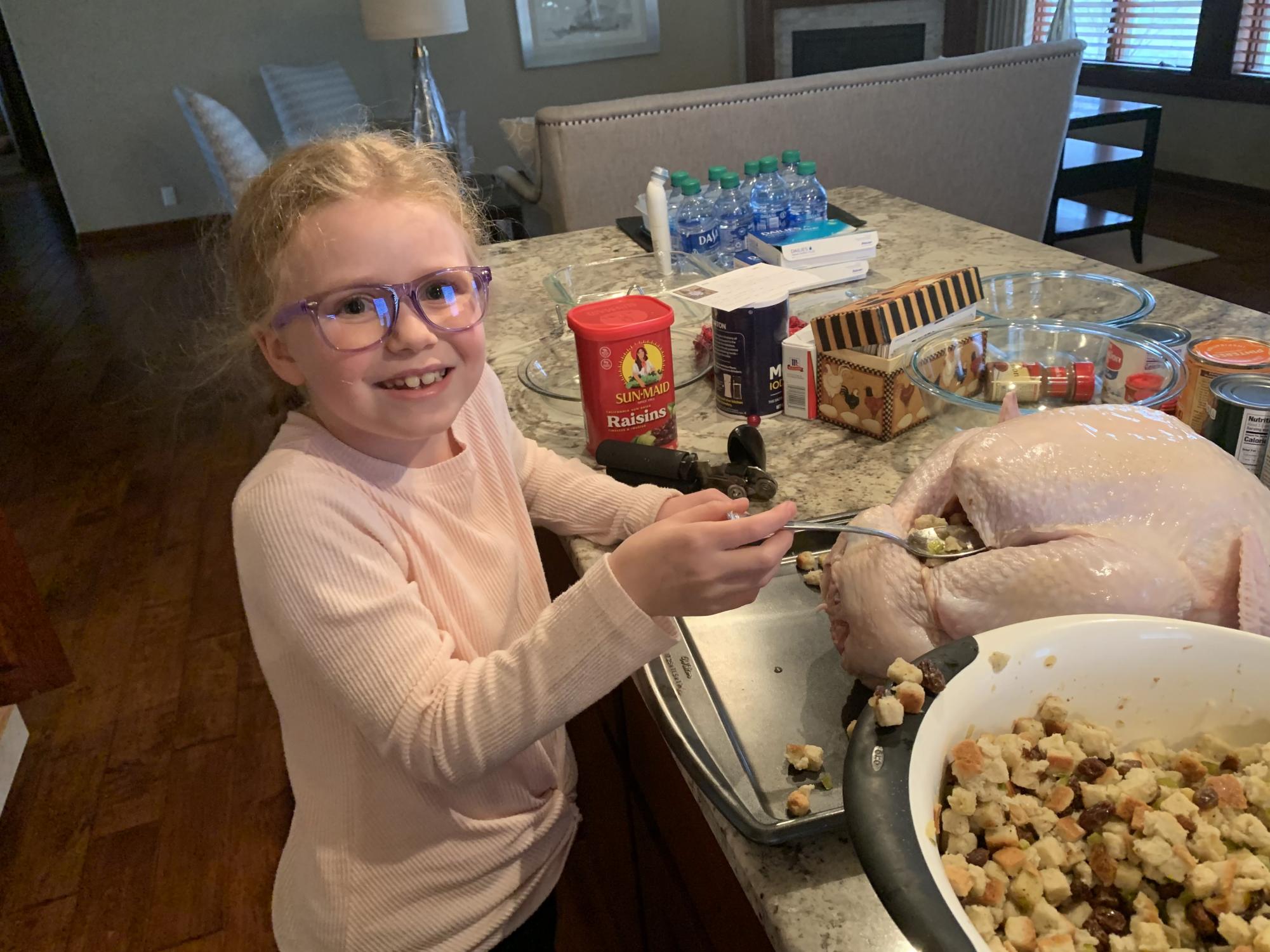My younger sister stuffing a real turkey for Thanksgiving dinner. Photo used with permission by Nichole Miner.
