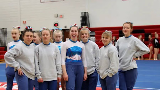 LHS senior Anna Leuning, third person from the left, is smiling at a gymnastics meet with the LHS gymnastics team. (Used with permission from KELOLAND)