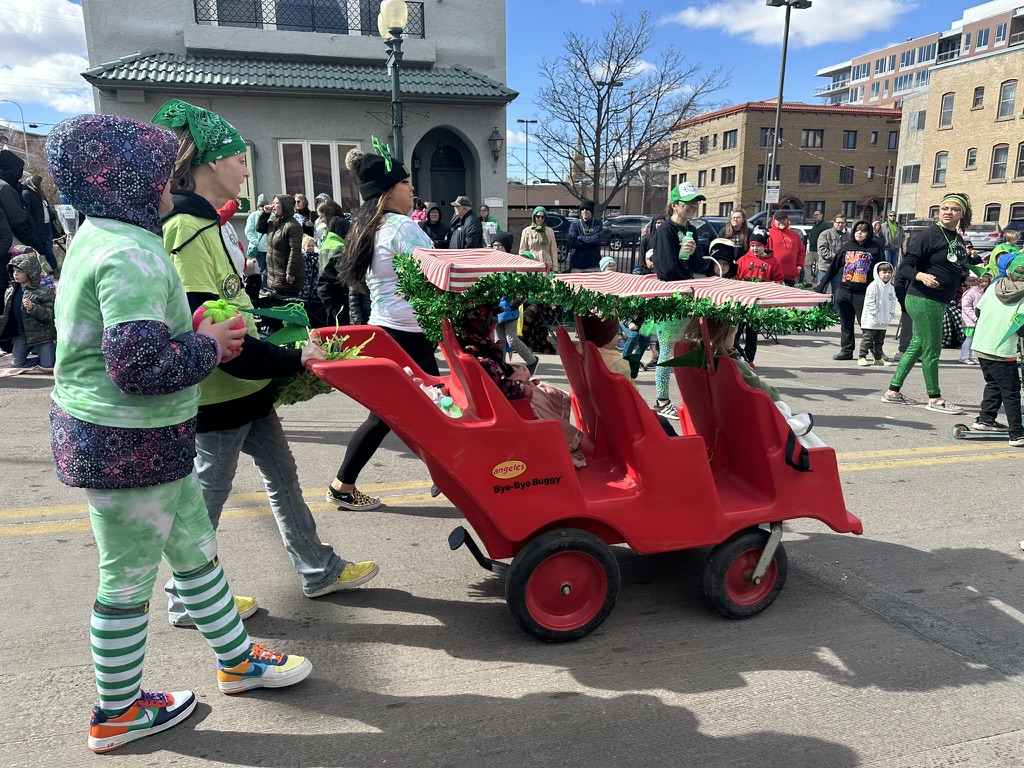 Three of the youngest members of the parade ride down in a stylish “Bye-Bye-Buggy” cart. 

