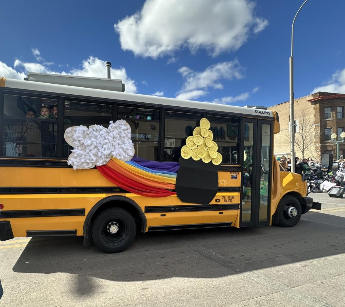 A yellow school bus features innovative gold coins at the end of the rainbow design. 
