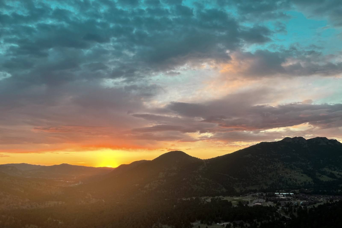 The sun can be seen shining behind the mountains early in the morning in Estes Park, Colorado, July 2023.