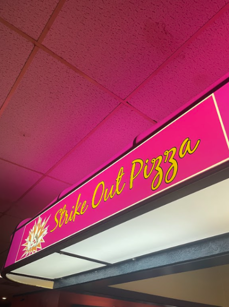 The Empire Bowl’s concession stand sign illuminates the dim bowling alley.
