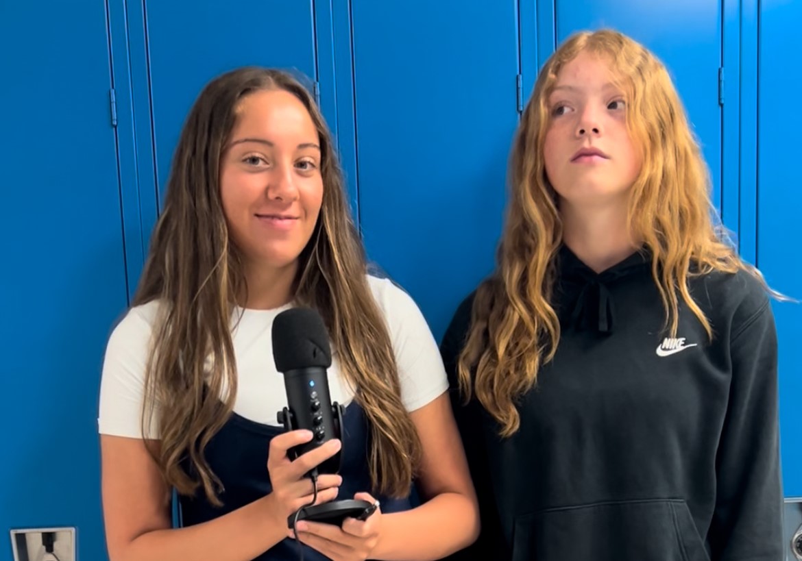 Ruby Hennies and Emerson Robertson surprising teachers with old photos asking them to autograph it.