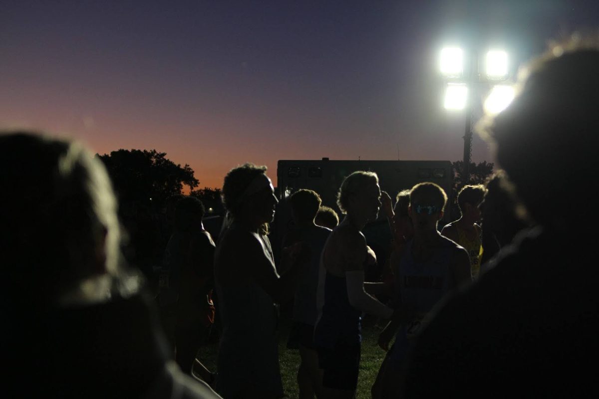 The LHS boys varsity team congratulates their teammates on an impressive performance, illuminated by the moon and floodlights.
