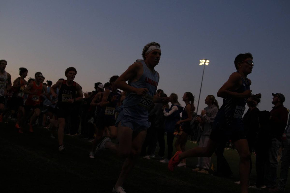 Twilight falls as boys varsity runner Arvid Nelsen sticks with a strong pack of competitors.