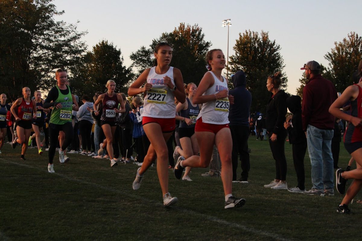In unison, girls varsity runners Emmeline Murray and Brielle Jenkins pace each other during their five-kilometer race.