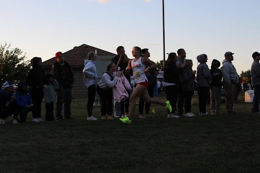 Top LHS girls varsity runner, Mia Kadi, strides solo through a straightaway at Yankton Trails during the 2025 Augie Twilight cross country meet.
