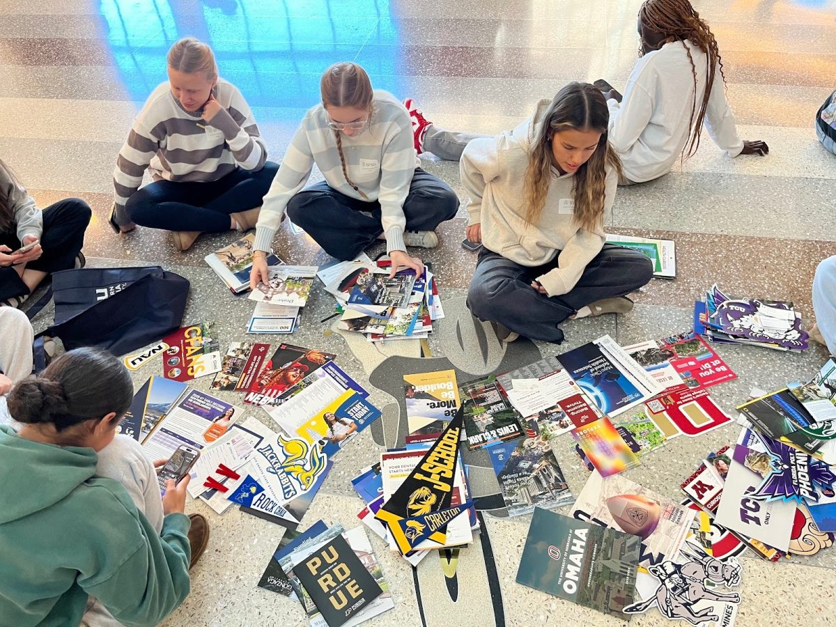 LHS students review their pamphlets, posters, stickers and banners from each college booth they visited.