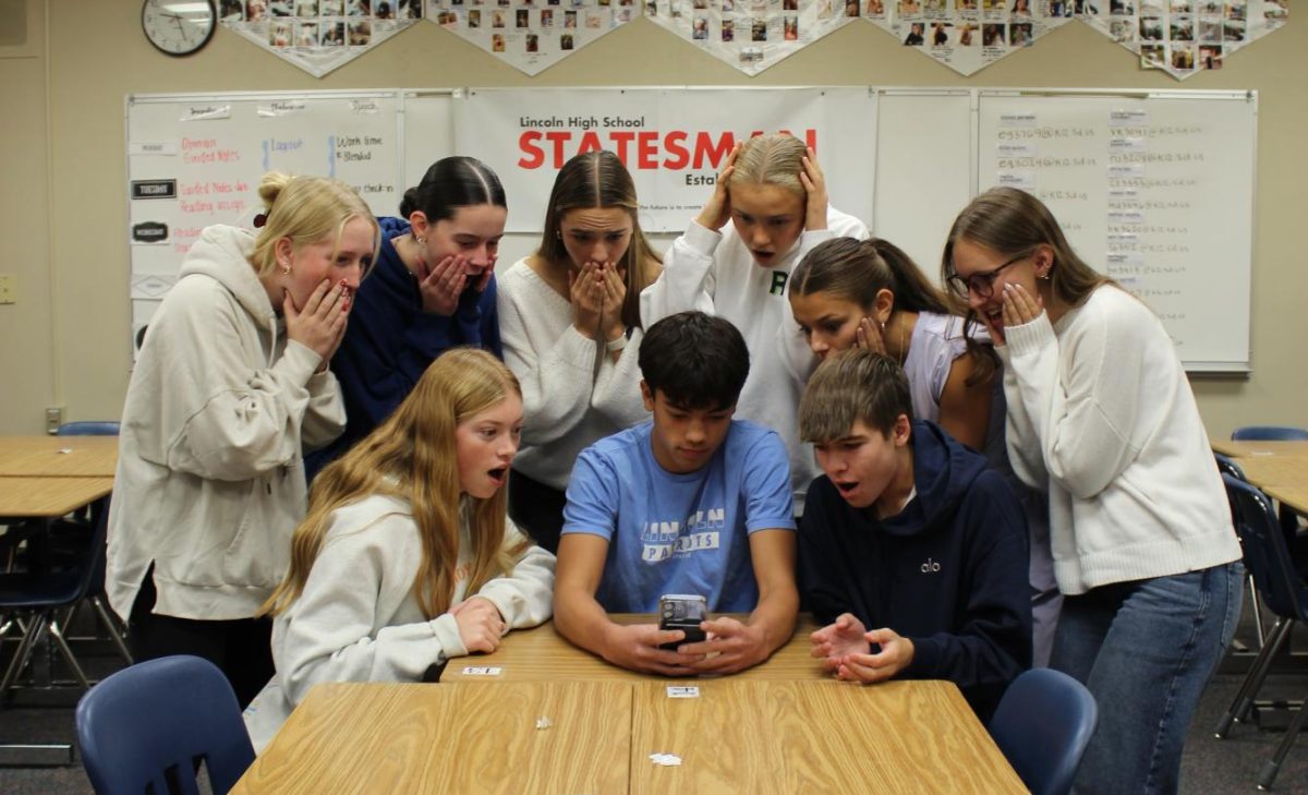 LHS junior Connor Husser plays Clash Royale while a crowd watches in awe of his skill.