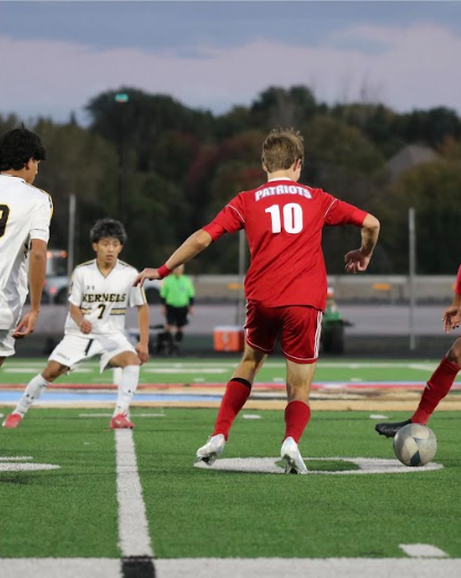Middle fielder Isaac Herrboldt dribbling the ball through Mitchell defenders
(Photo used with permission by @lhs_patriots_boys_soccer).